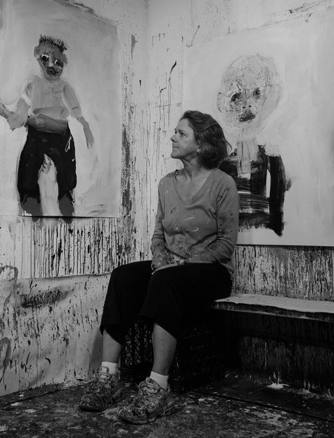 امرأة جالسة تتأمل لوحة زيتية