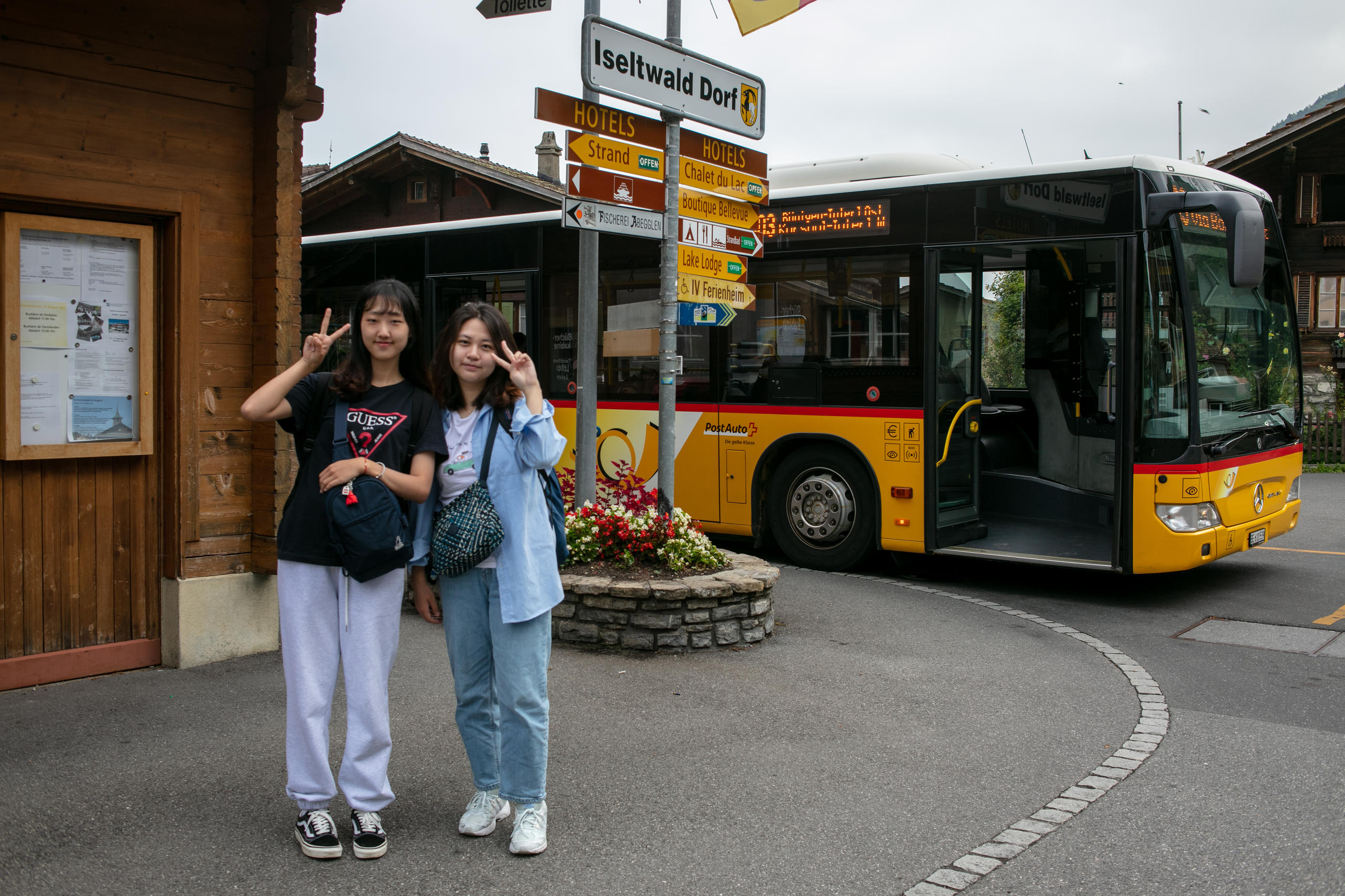 Korean tourists posing in front of post bus 103. They are visiting the place where Crash Landing on You was filmed.