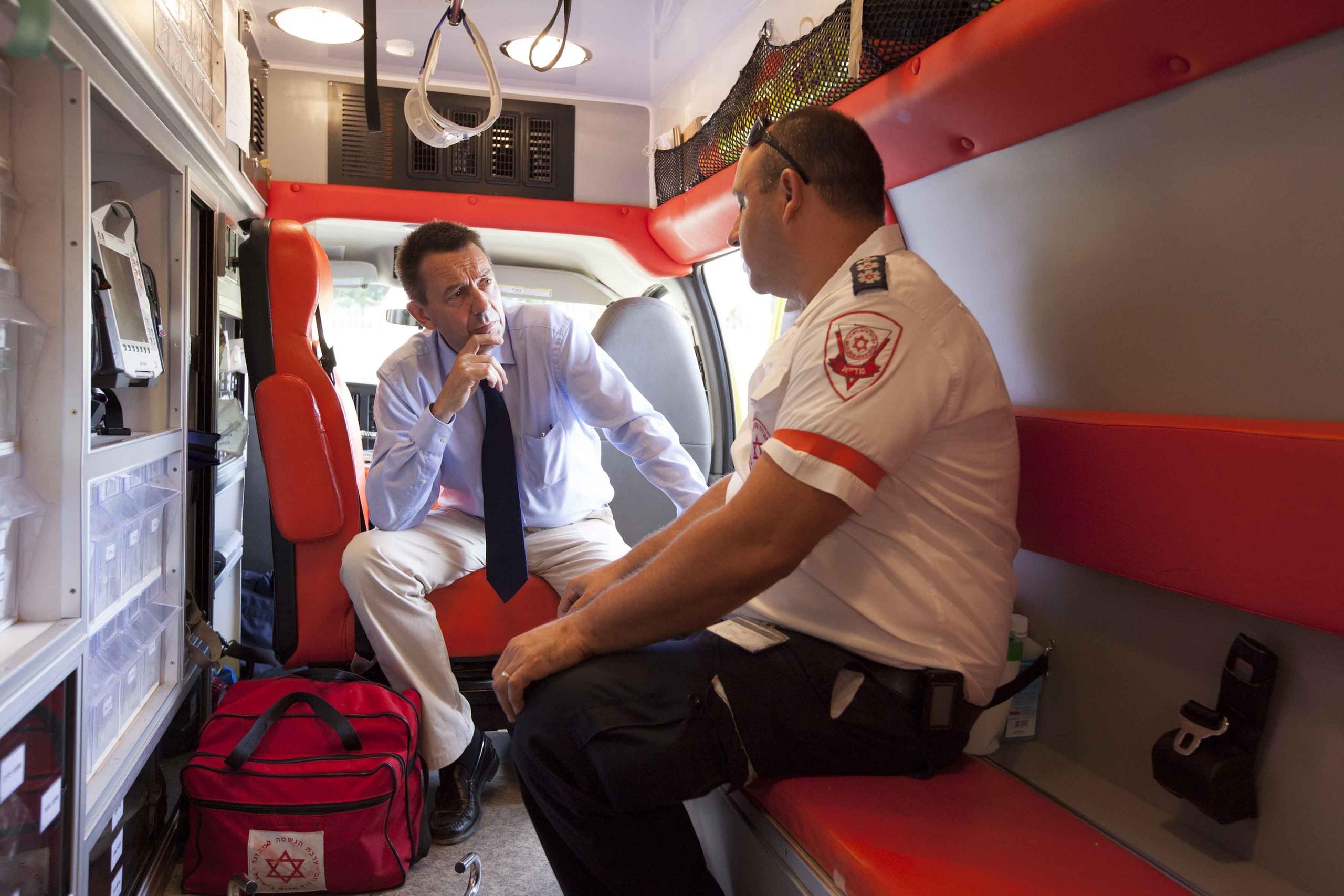 رجل يستمع إلى مسعف داخل سيارة إسعاف
