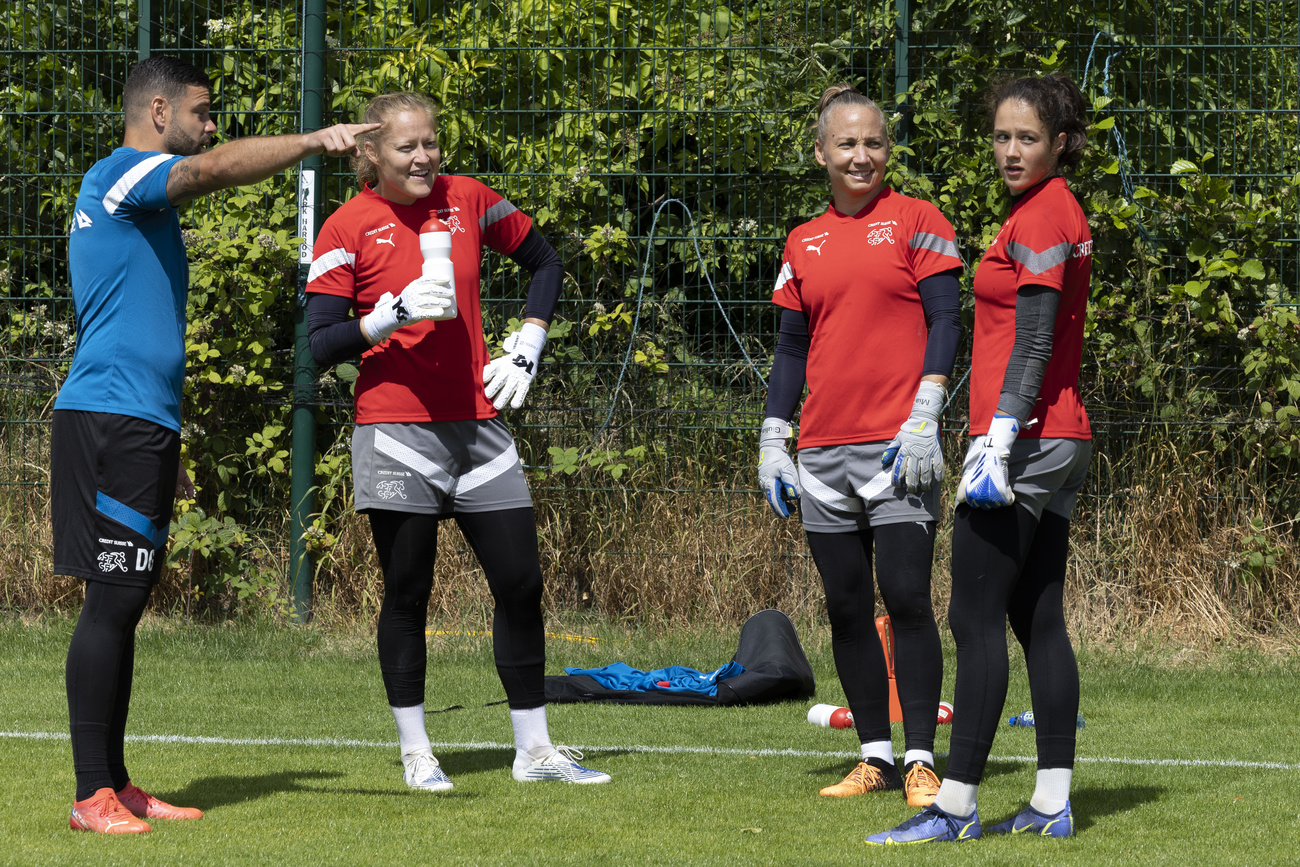 three women football goalkeepers and a coach