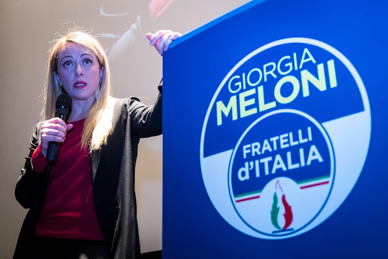 giorgia meloni davanti al logo di fratelli d italia