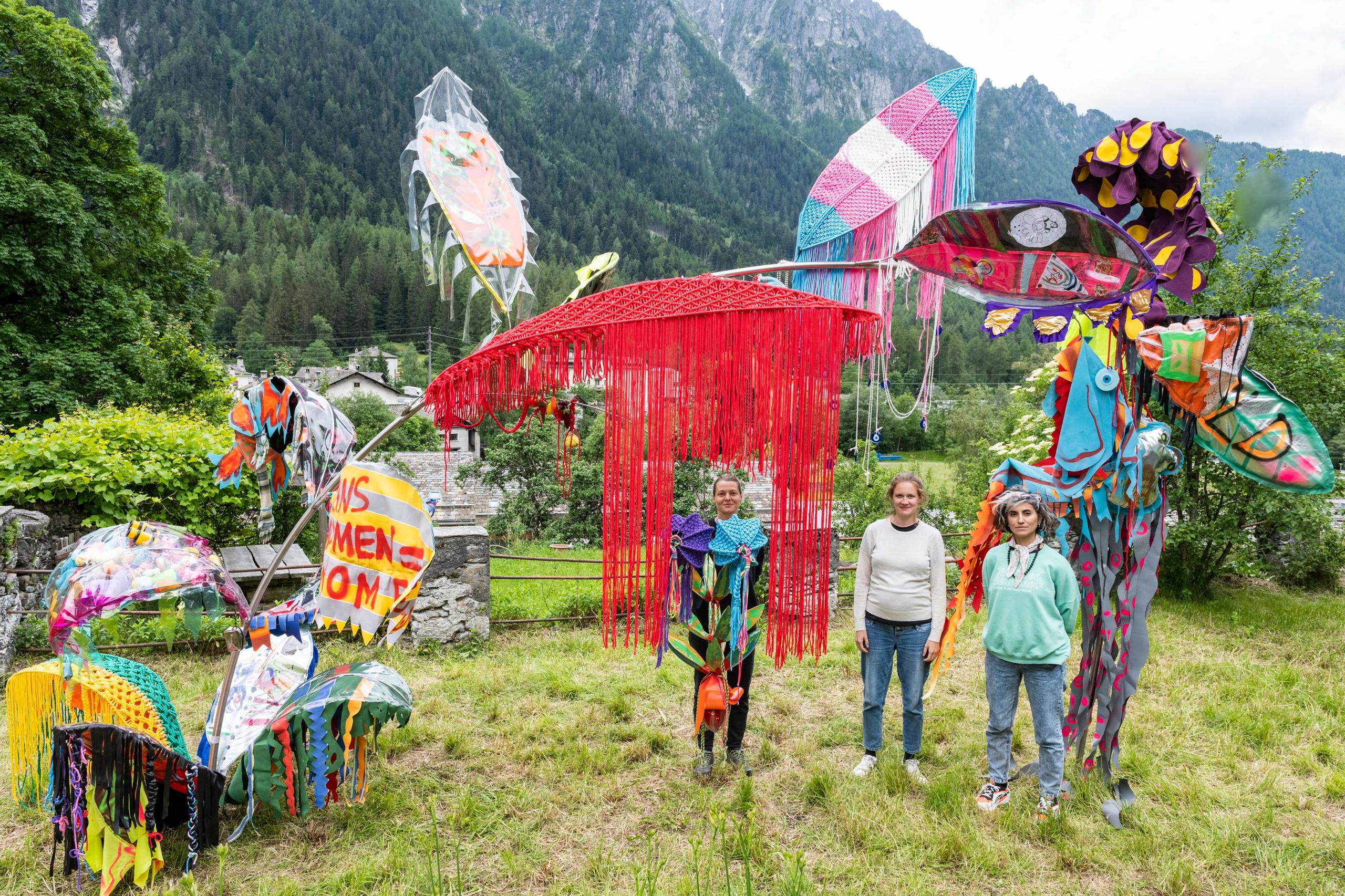 Kunstwerk auf Wiese, drei Frauen