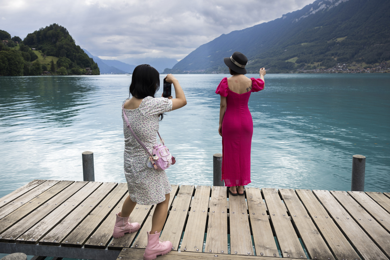 woman being photographed in front of a lake