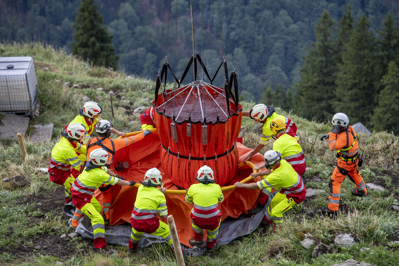 Firemen deliver water to the Alp