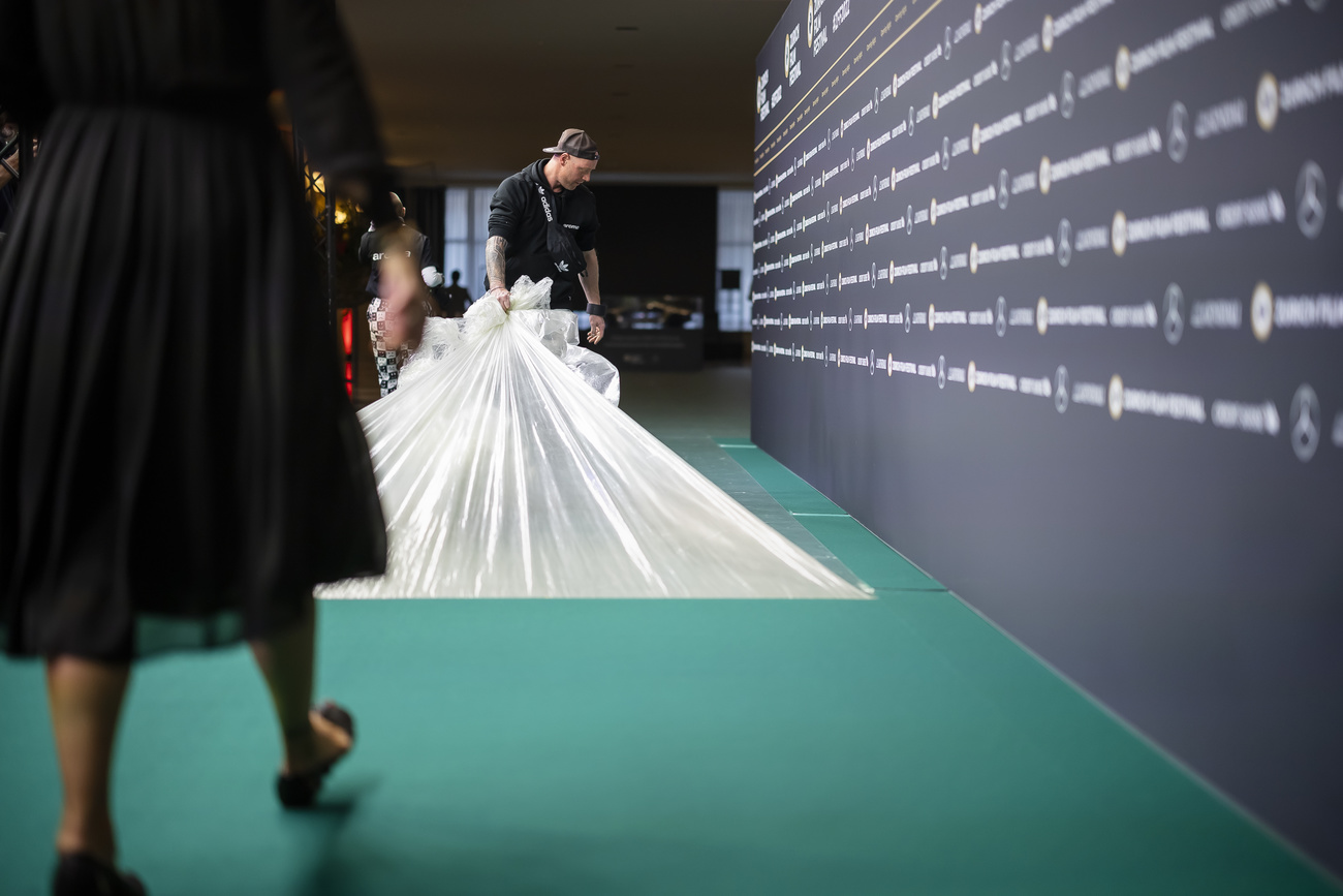 impiegato rimuove plastica protettiva da tappeto verde