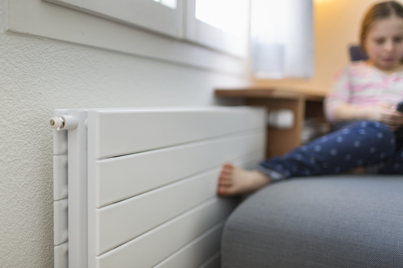 Girl sitting next to a radiator