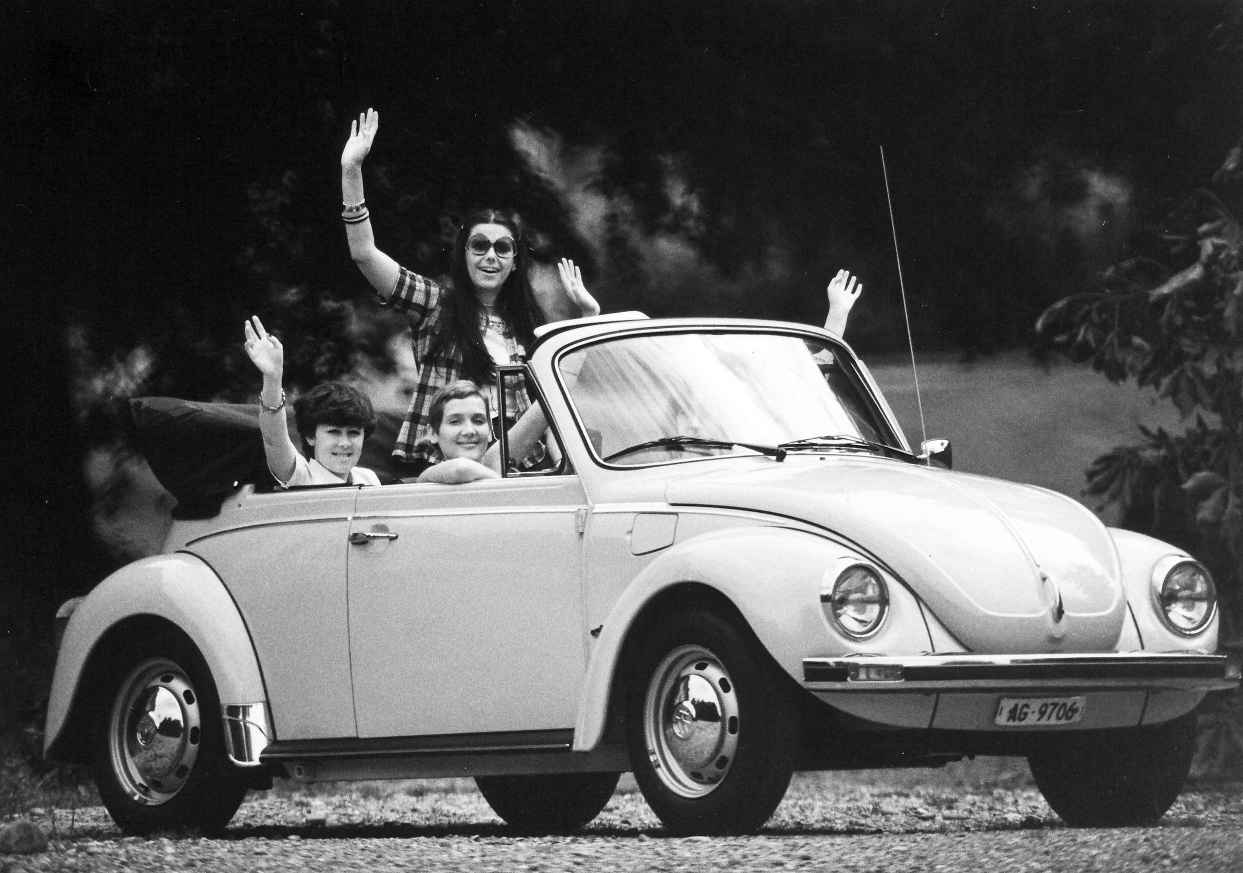 Gente saludando desde un coche antiguo de la época