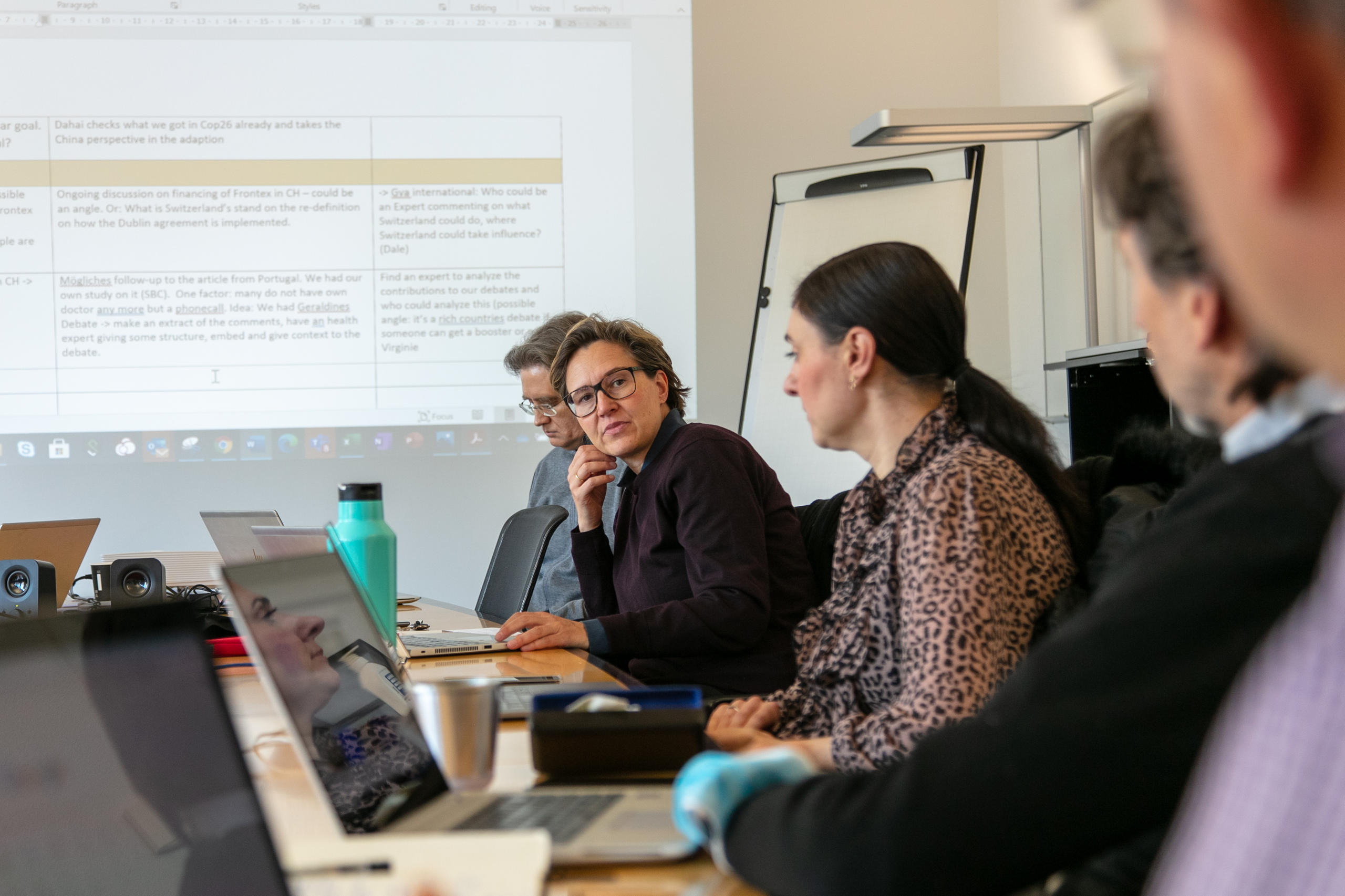 Mitarbeitende an Sitzung die zusammen sprechen