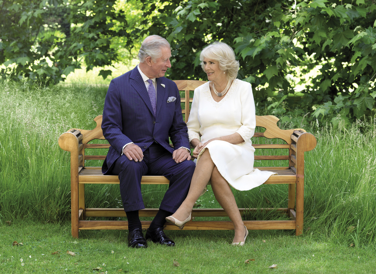 Carlo e Camilla seduta su una panchina.