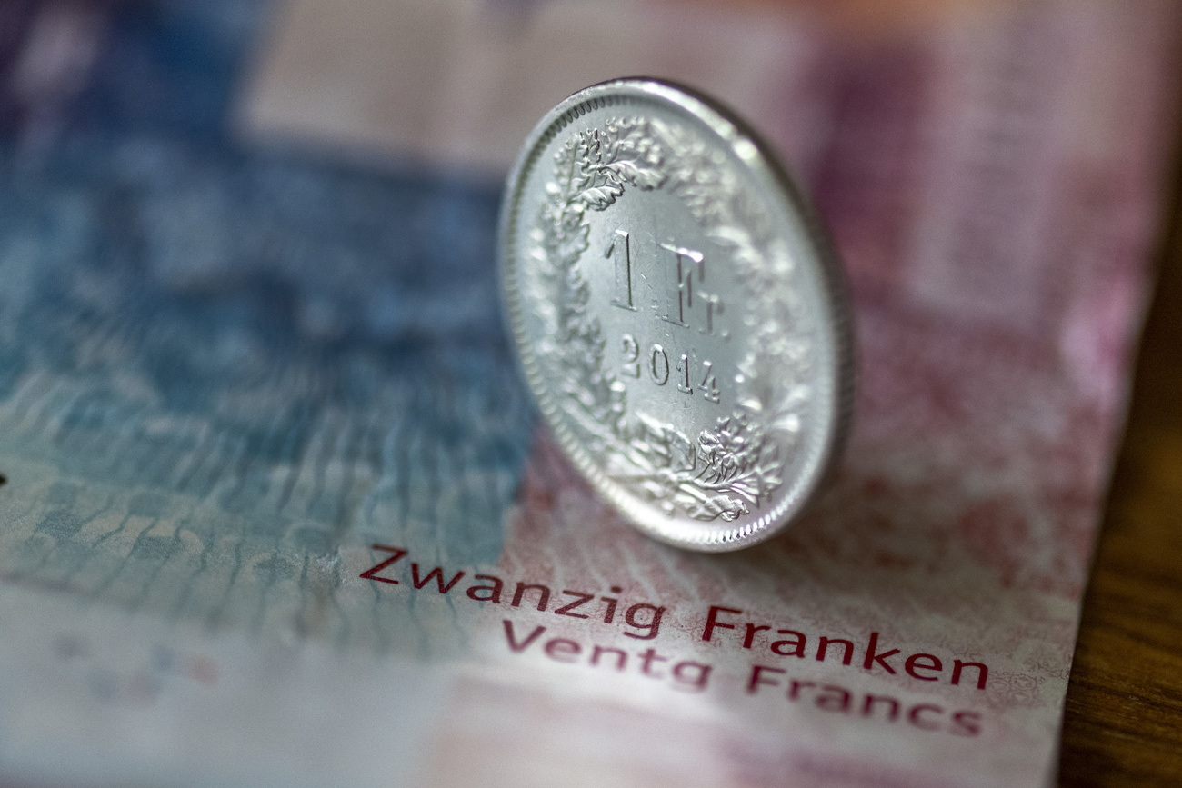 ein Einfränkler steht auf einer 20er-Note