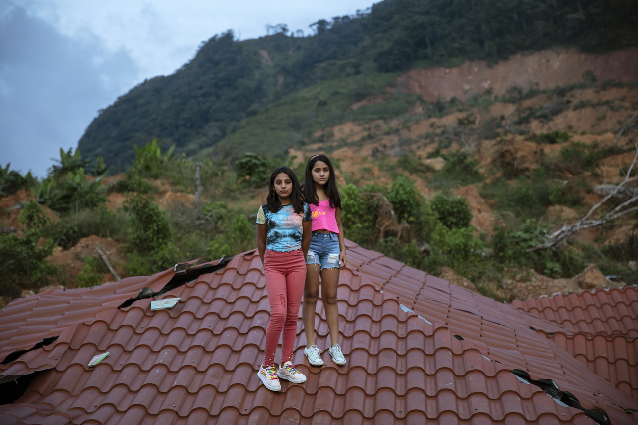 Duas gêmeas posam em cima de um telhado