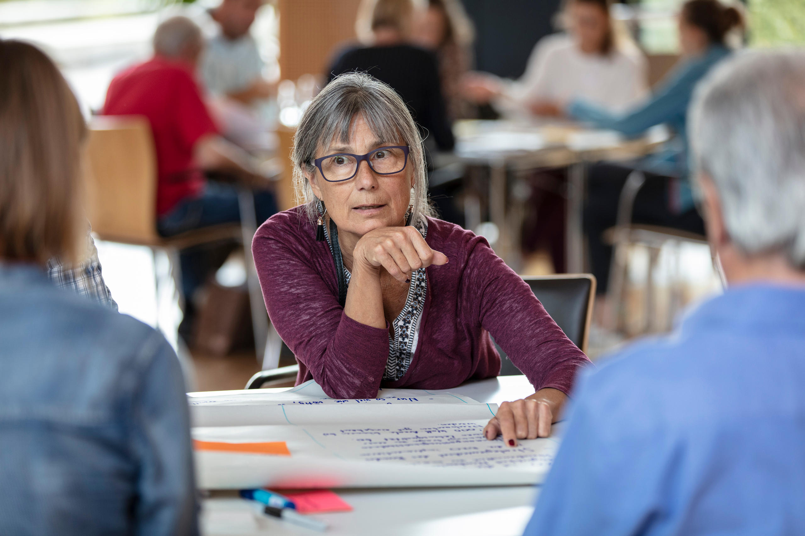 Eine Frau, die an einem Tisch sitzt.