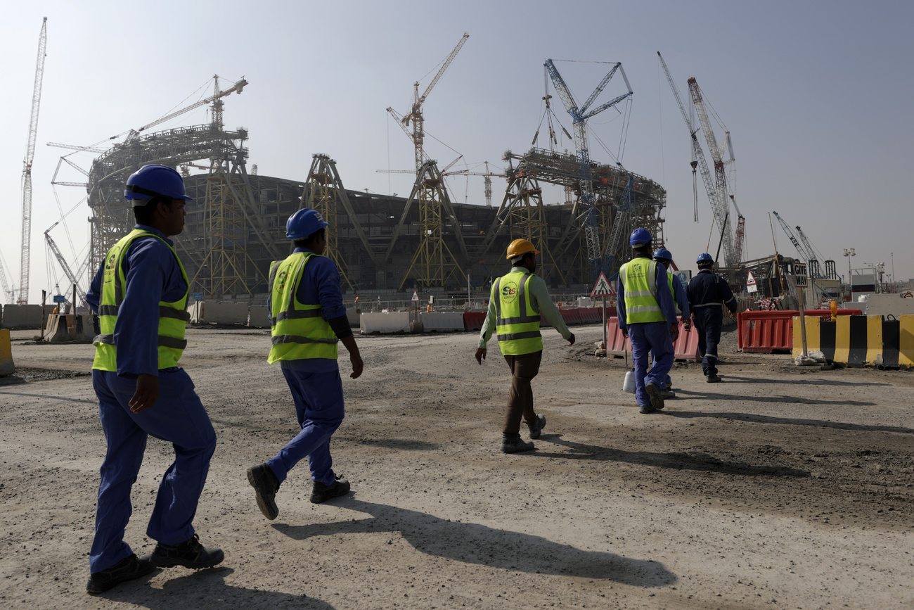 Workers walk to the Lusail Stadium, one of the 2022 World Cup stadiums, in Lusail, Qatar, Friday, Dec. 20, 2019.