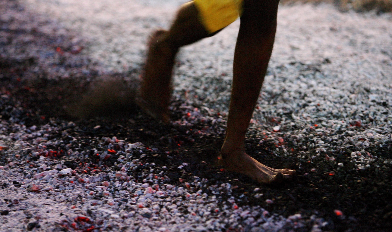 Person walking barefoot over hot coals