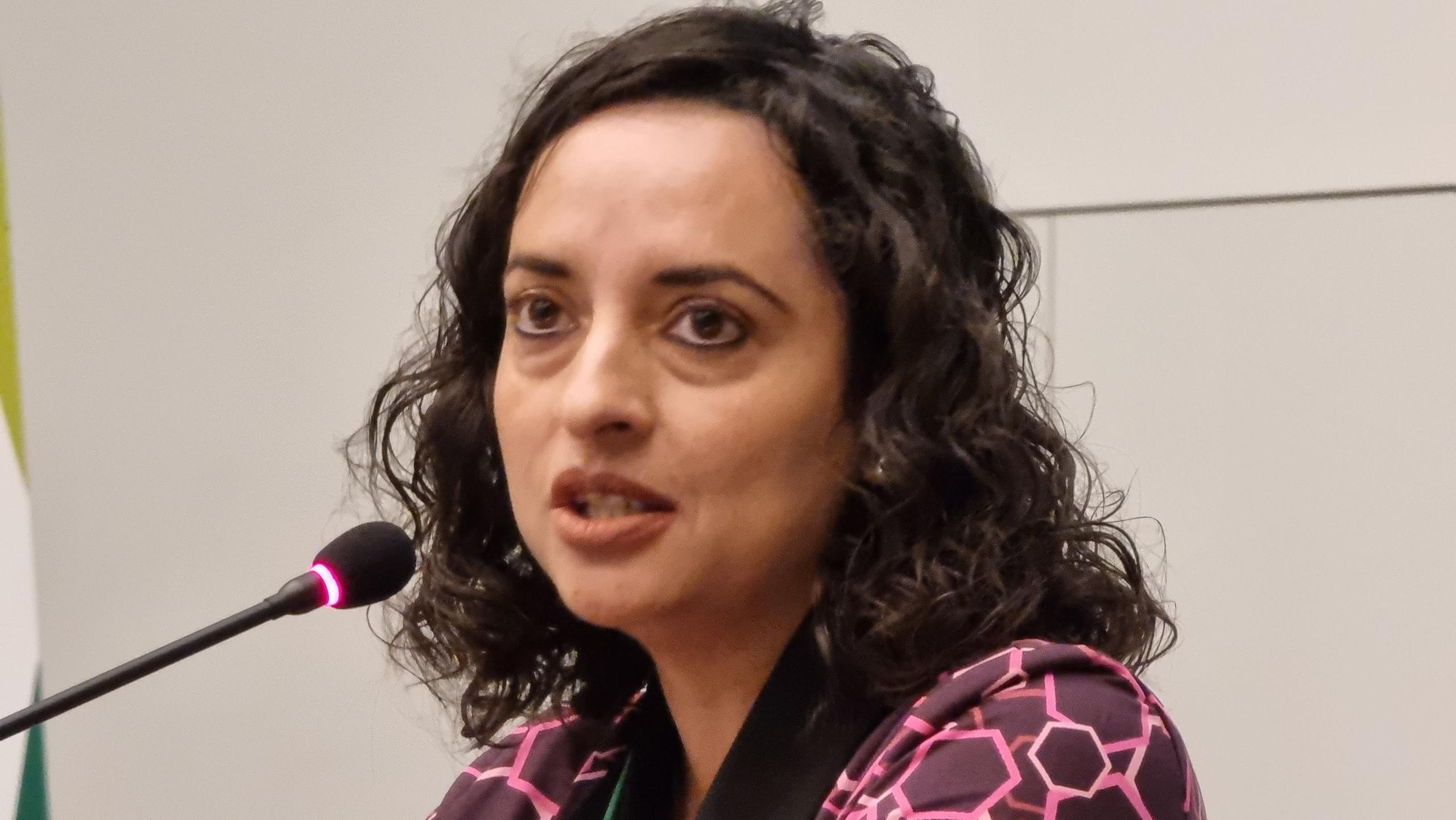 Junge Frau spricht in ein Mikrofon