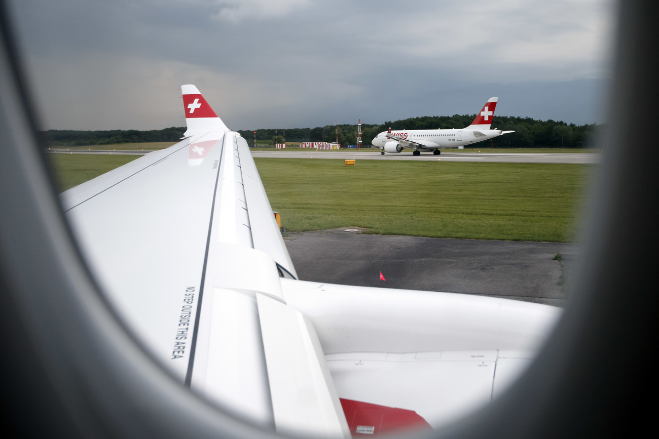 View of a Swiss International Air Lines plane taken from the window of another plane.