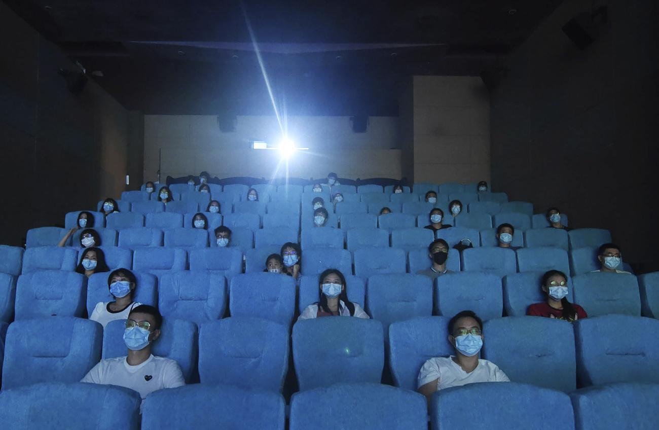 Leute mit Maske und Abstand im Kino