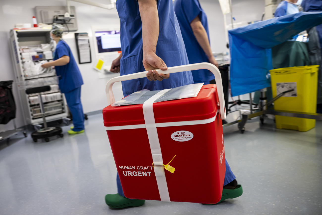 Medical workers carries an organ transplant box in a hospital in Geneva.