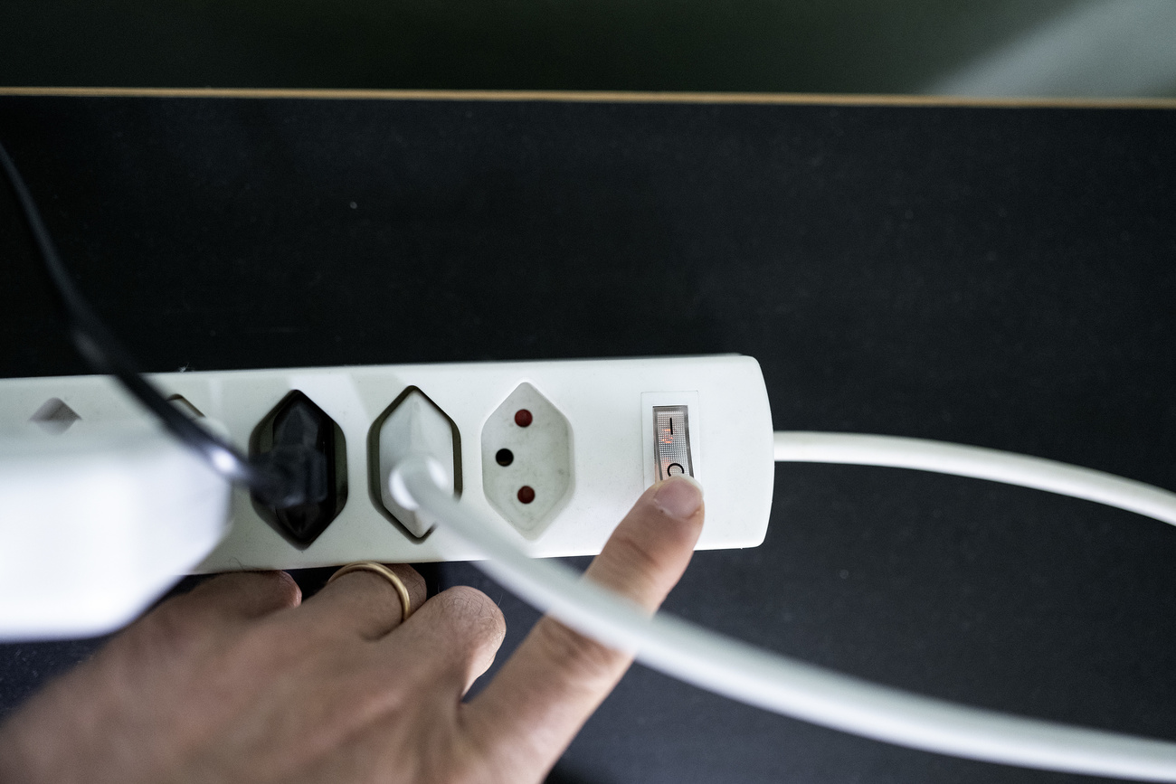 mano di uomo spegne intetrruttore multipresa