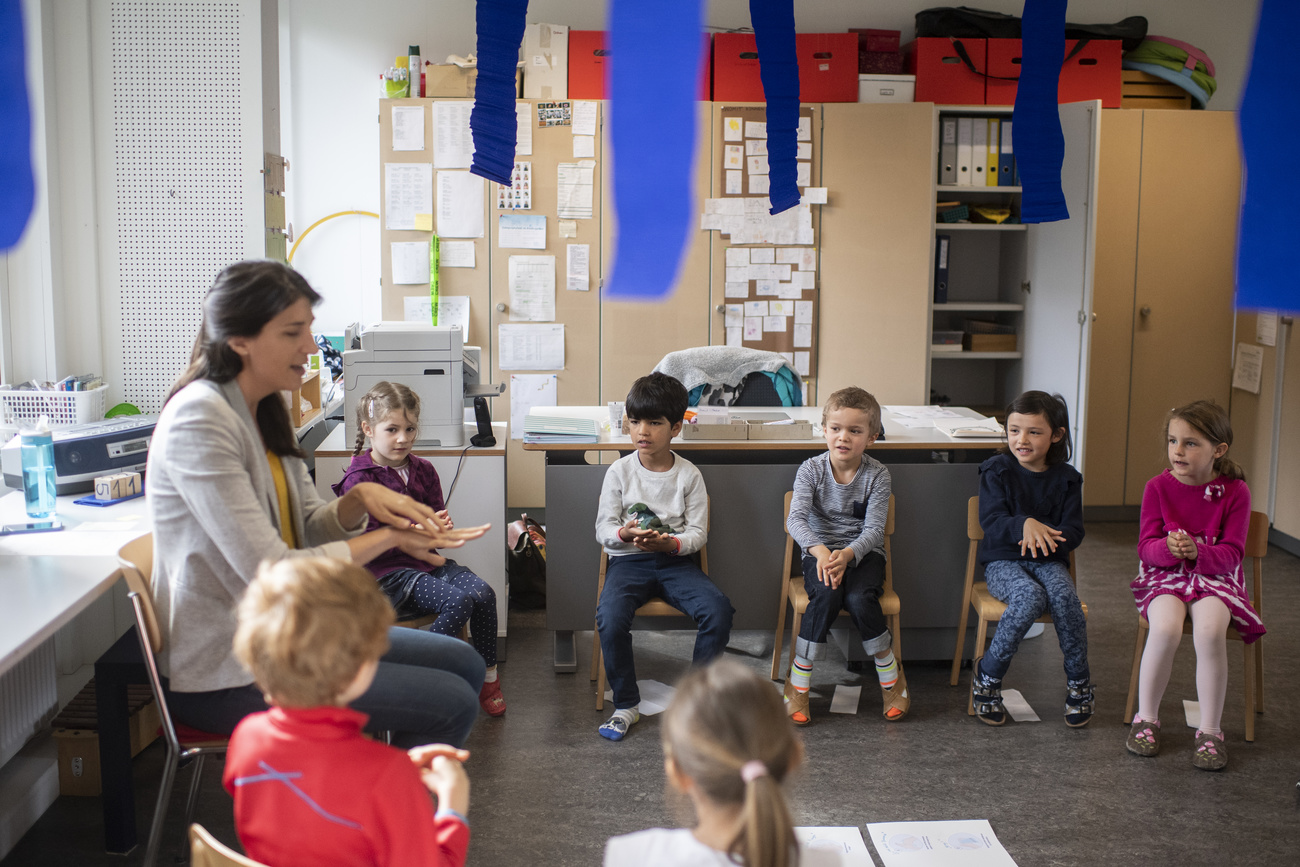 Maestra con sus alumnos en un salón de clase.