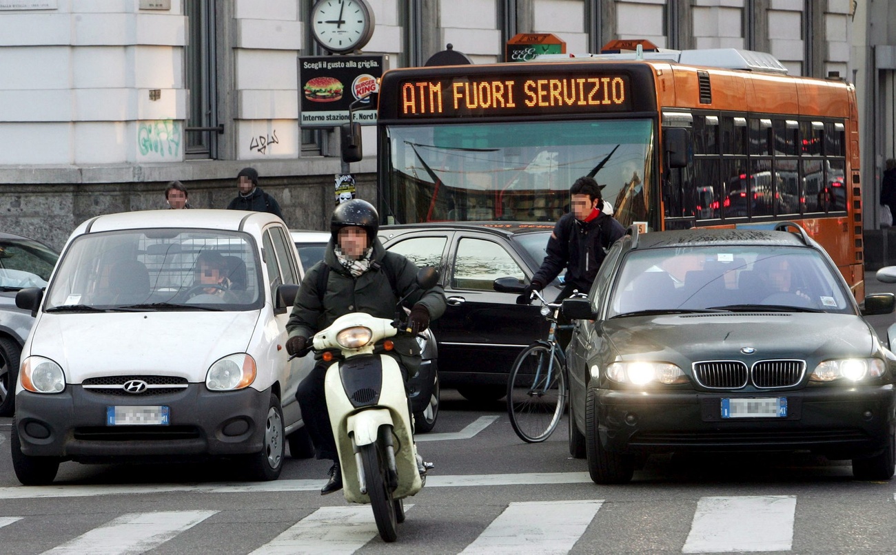 due auto, uno scooter e un bus nel traffico