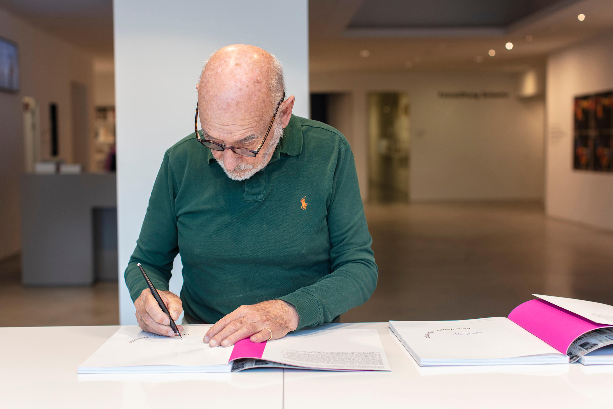 Peter Knapp beim signieren von Ausstellungskatalogen