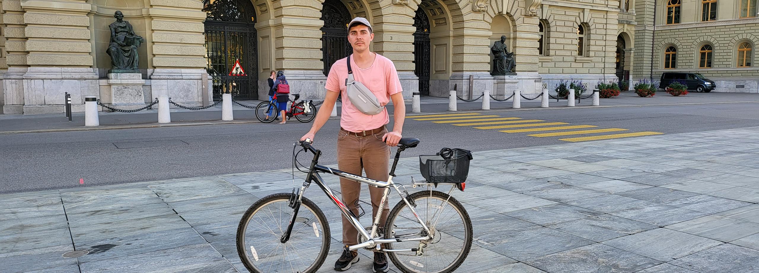 un chico con una bicicleta en una plaza emblemática de Berna