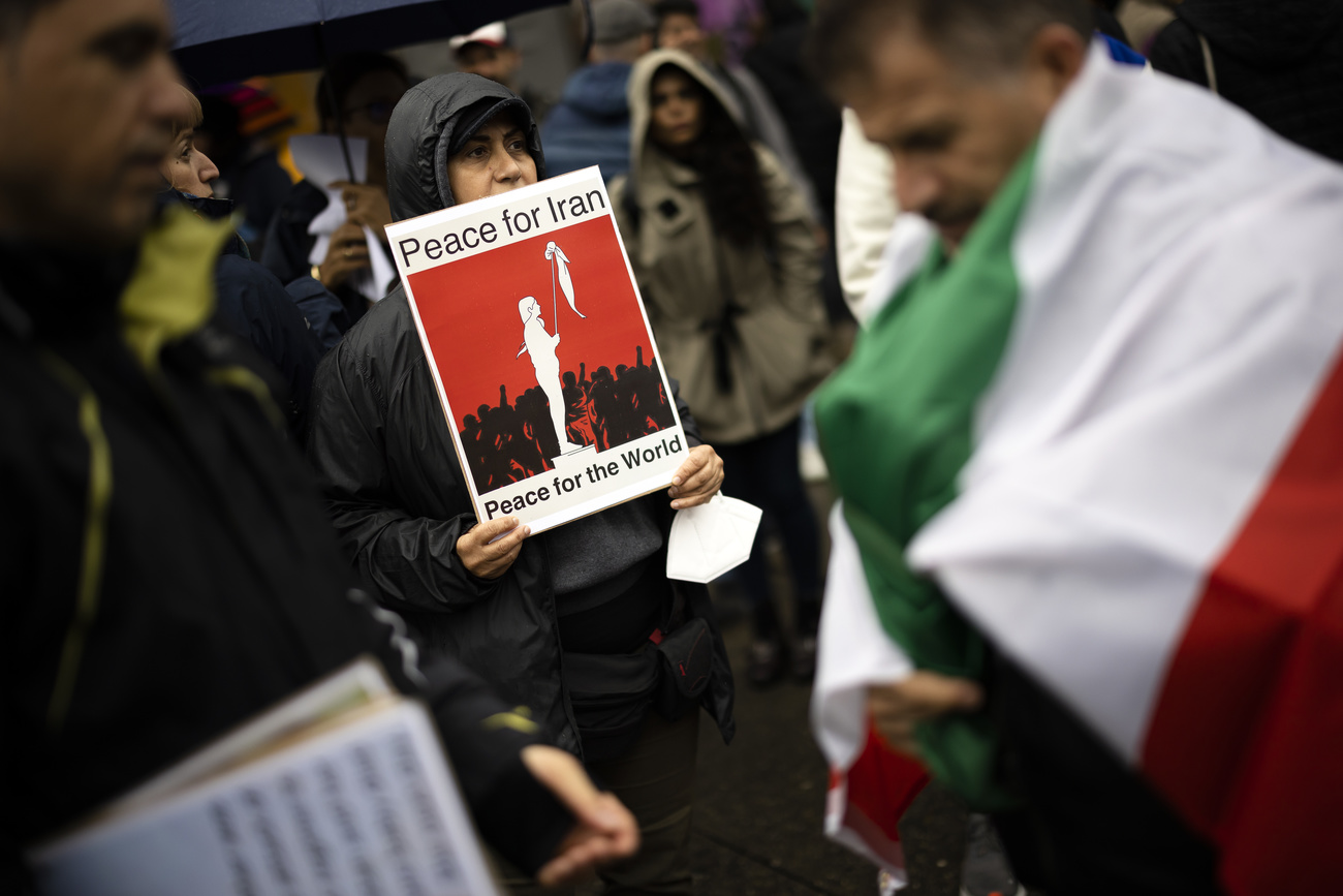 Female protestor in Bern holds up a sign saying Peace for Iran, Peace for the world.