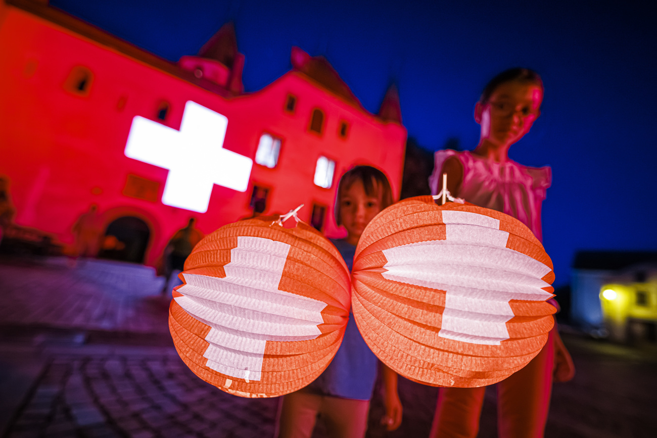Kinder schwenken Lampions mit Schweizerkreuz