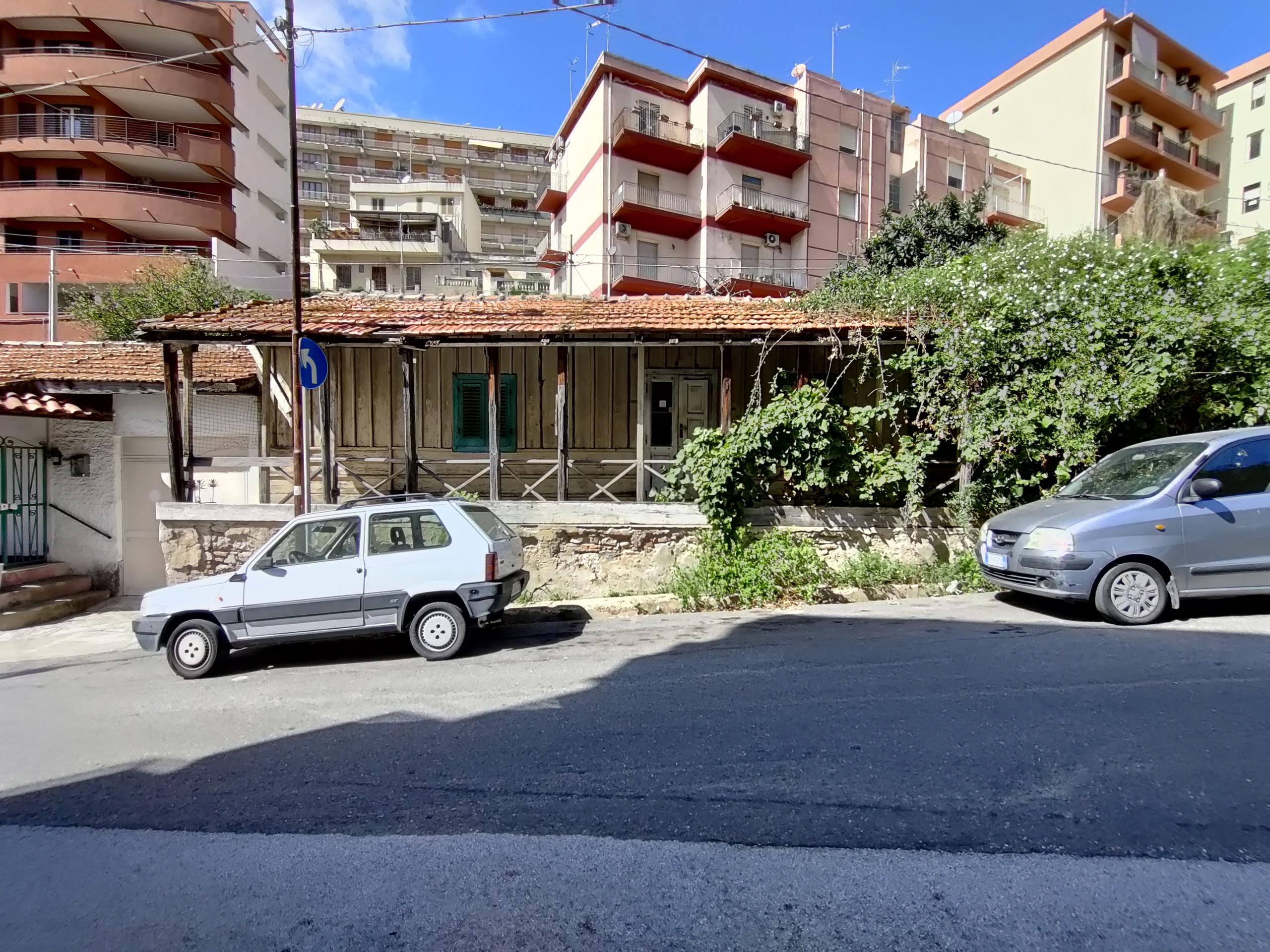 chalet di legno attorniato da palazzi di cemento