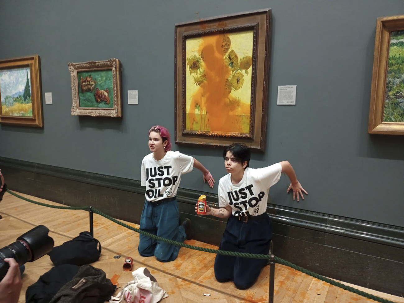 Due attiviste davanti alla tela imbratatta di Van Gogh.