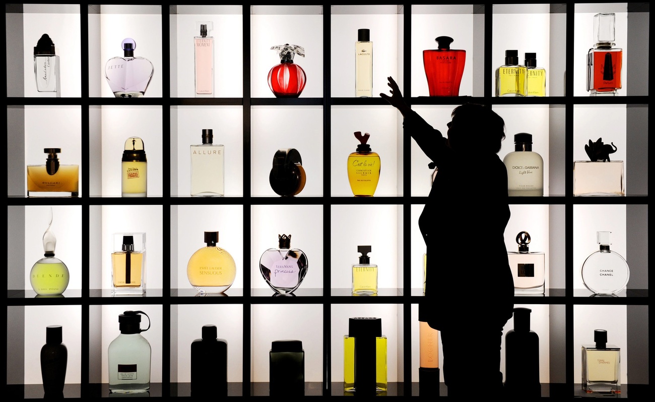 Femme devant des bouteilles de parfum