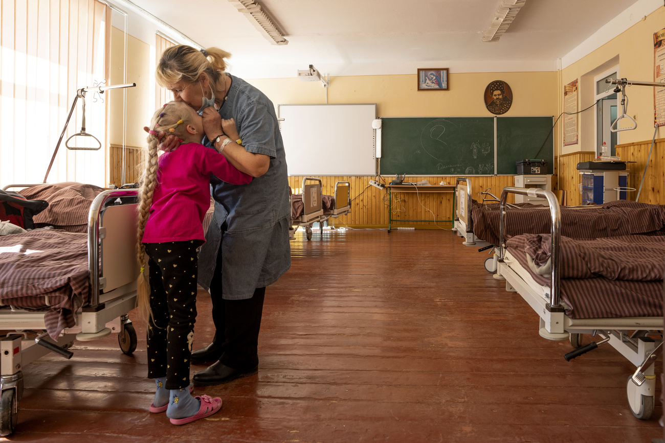 Una mujer y una niña se abrazan en una sala de hospital.