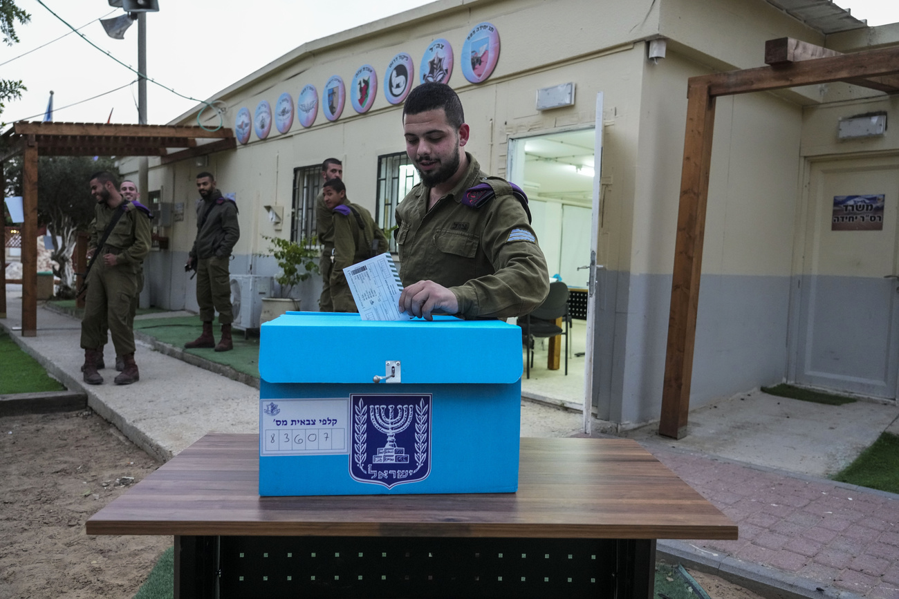 Un soldato israeliano inserisce la sua scheda di voto in un urna