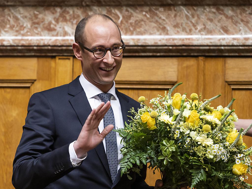 رجل يحمل باقة من الورود داخل قاعة اجتماعات مجلس النواب السويسري