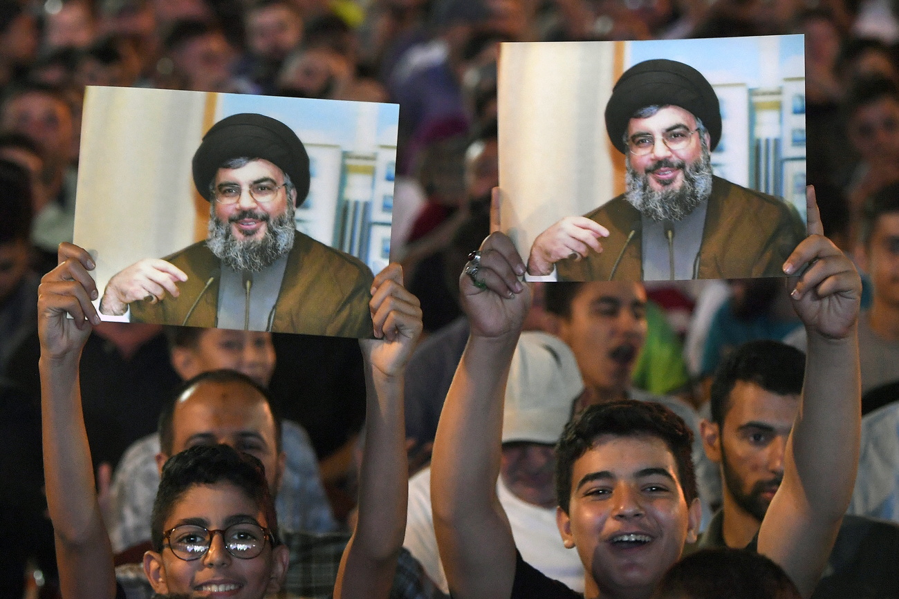 أنصار حزب الله وفي الخلفية صورة لزعيمهم