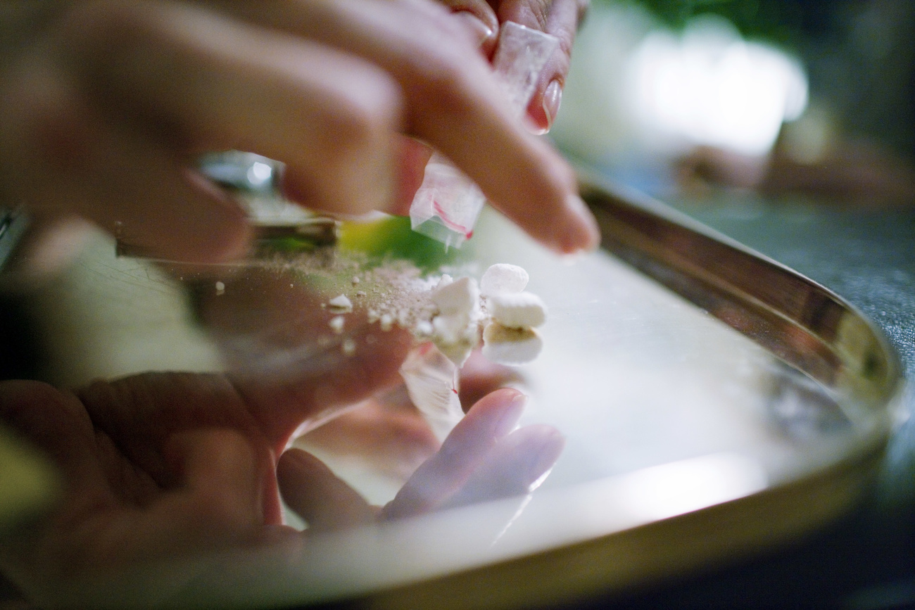 Cocaina versata da una bustaina su un vassoio.