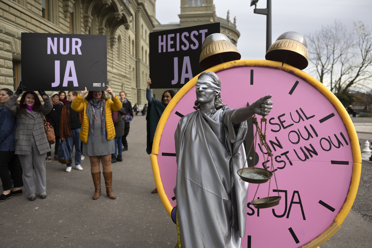 donna vestita da giustizia bendata viene svegliata da una mega sveglia sulla quale c è la scritta solo un sì è un sì