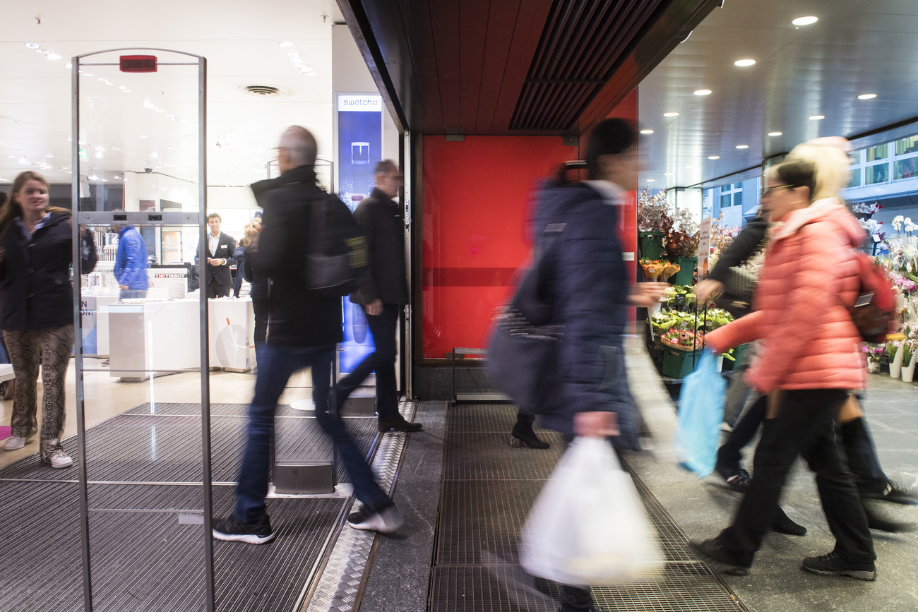 Diverse persone entrano ed escono da un grande magazzino di Lugano.