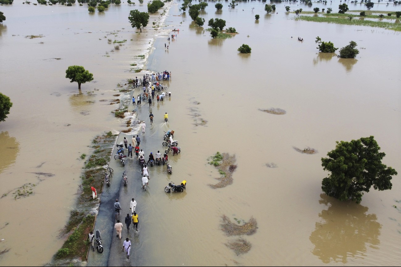 gente che cammina lungo una strada sommersa dall acqua