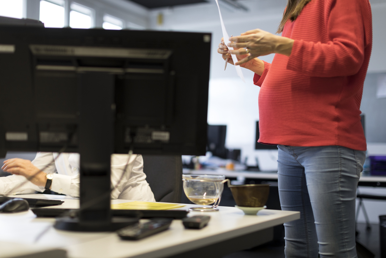 donna incinta in piedi in ufficio