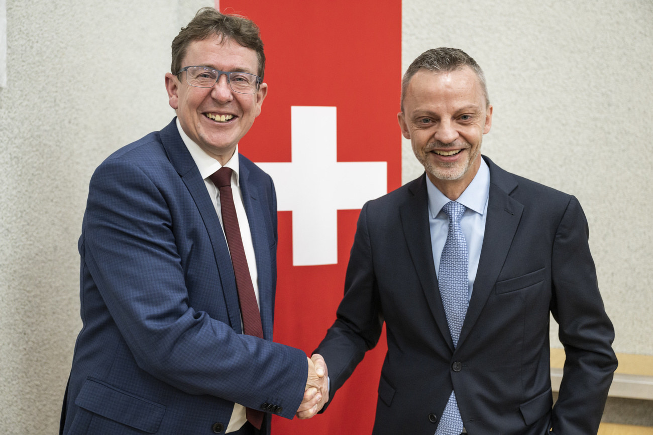 Albert Rösti y Hans-Ueli Vogt se dan la mano.