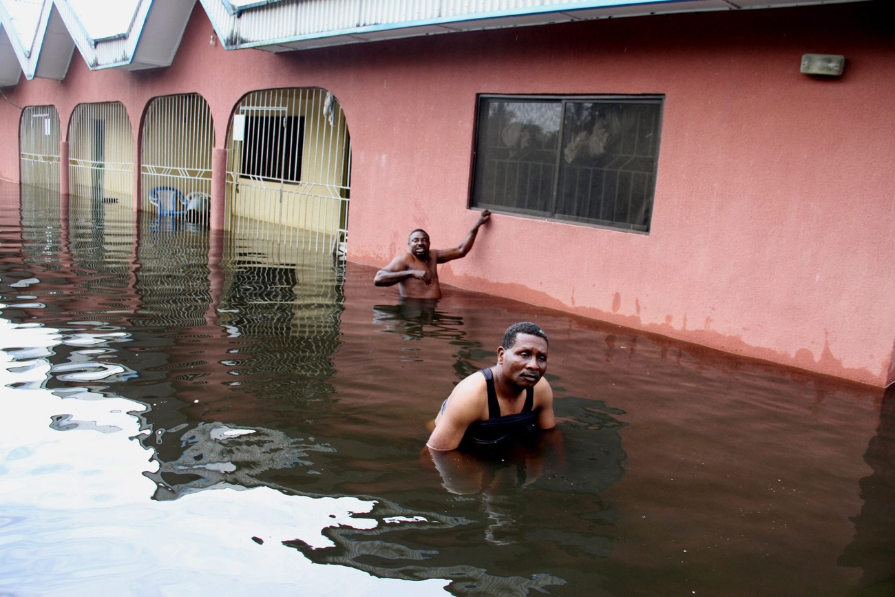 People wade through a flooded street in Nigeria in 2012.