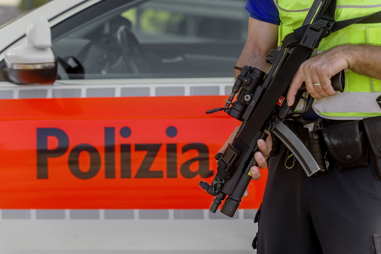 Un veicolo della polizia ticinese con un poliziotto.