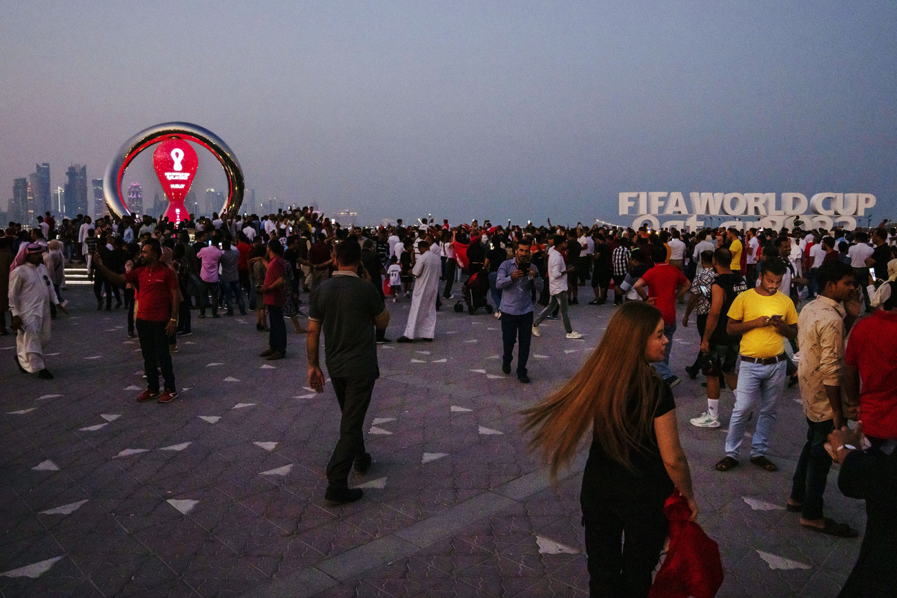 Mucha gente en un mirador con el símbolo de la FIFA y la ciudad de Doha detrás