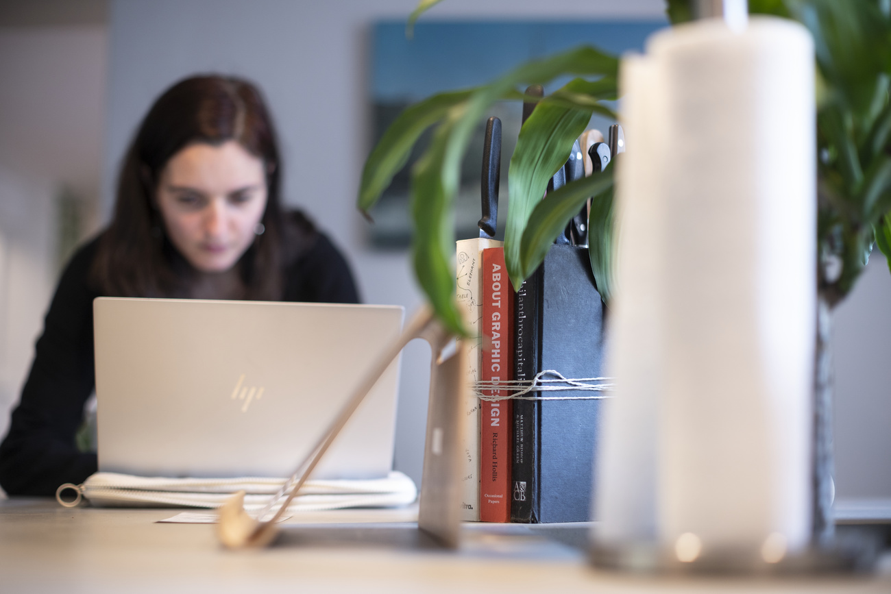 donna lavora dietro allo schermo di un pc portatile