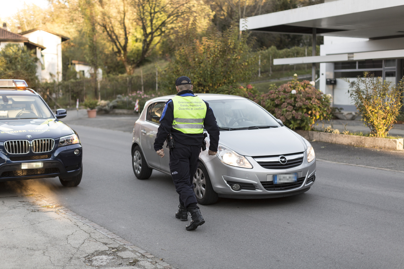 Una guardi di confine elvetica ferma un automobile con targhe straniere.