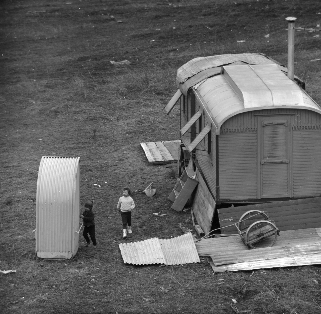 Long shot view of two children and a trailer