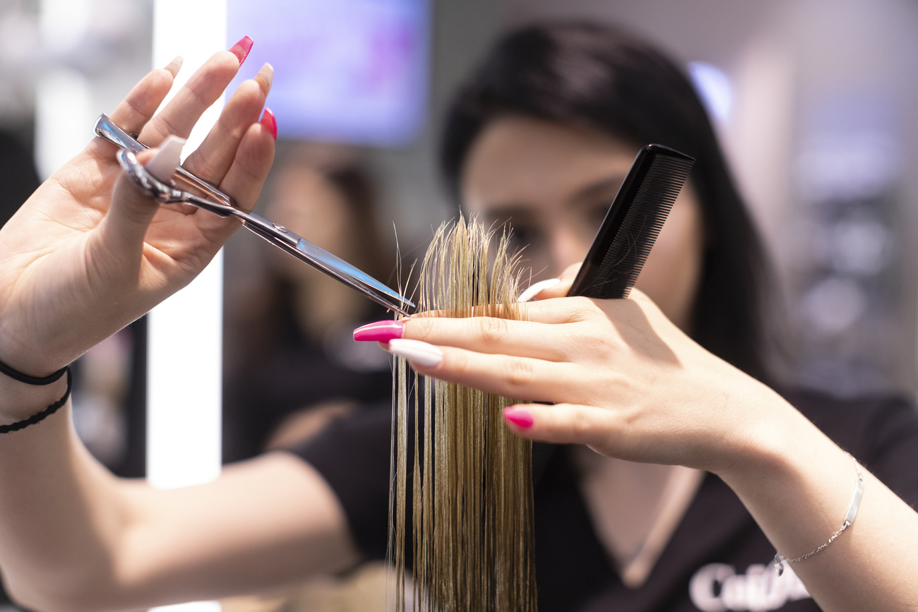 Peluquera cortando el pelo a una clienta.