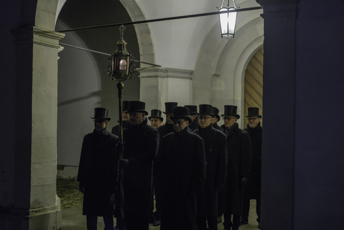 uomini con mantelli e cilindri neri